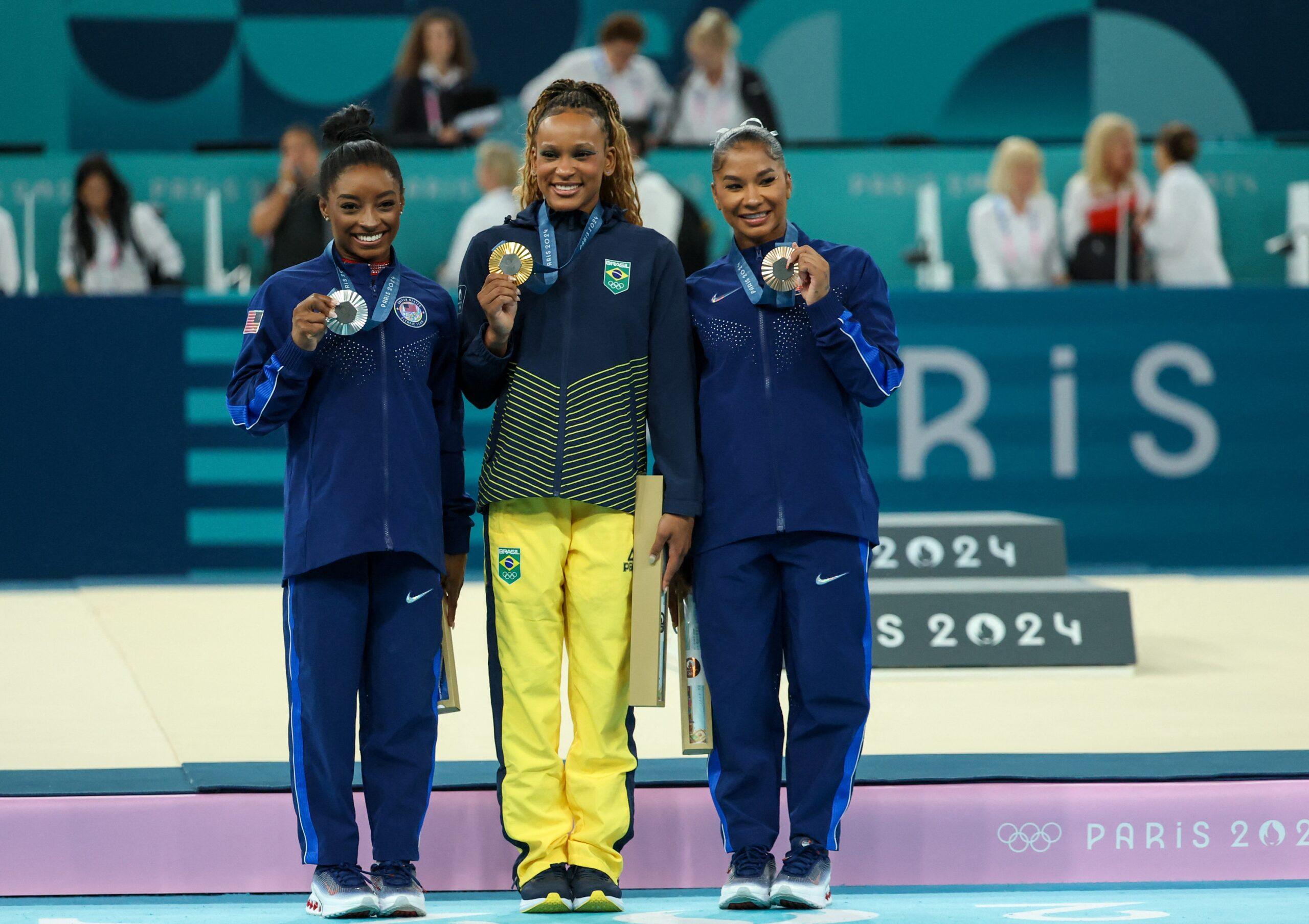 de France, France: Simone Biles of the United States, Rebeca Andrade of Brazil, and Jordan Chiles of the United States with their medals on the floor 