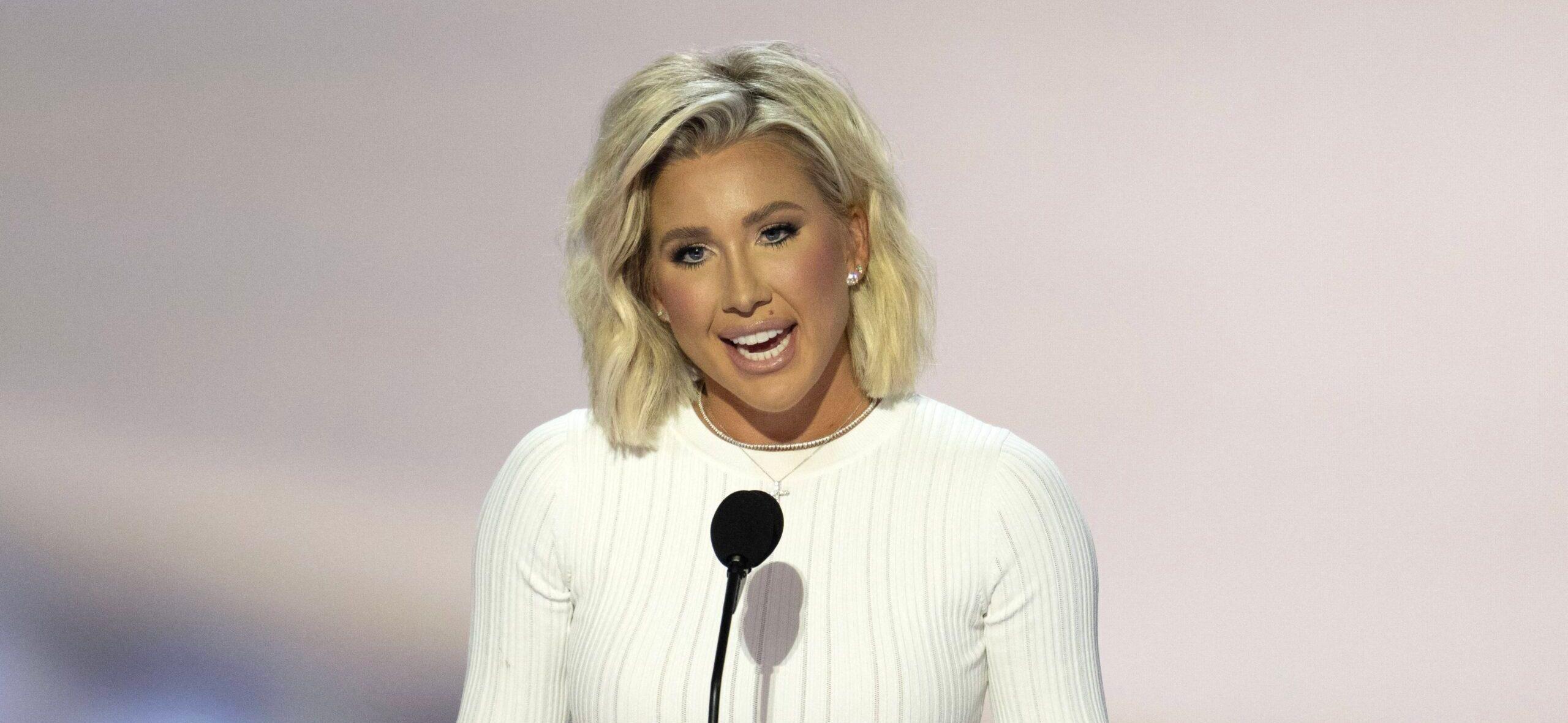 Savannah Chrisley speaking in front of a crowd of people at the RNC.