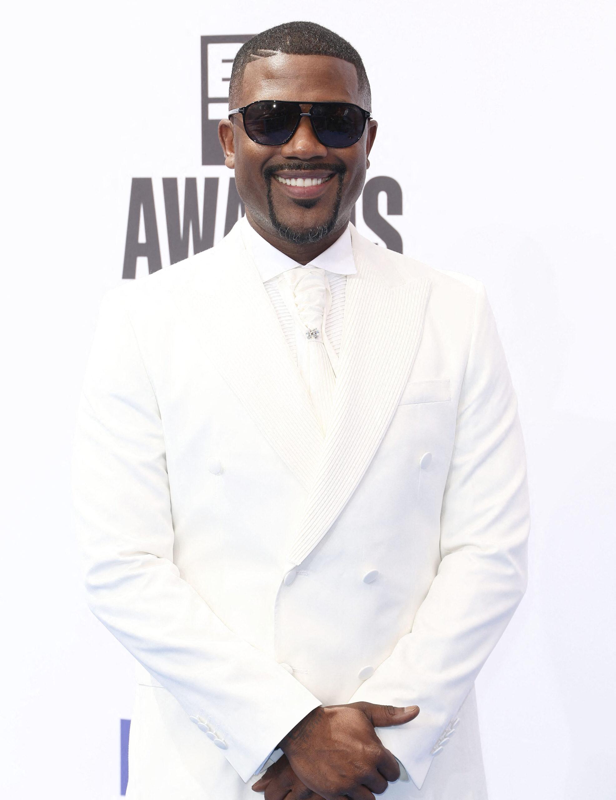 Ray J posing in all white on the red carpet.