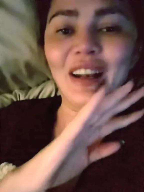 Chrissy Teigen lying in bed