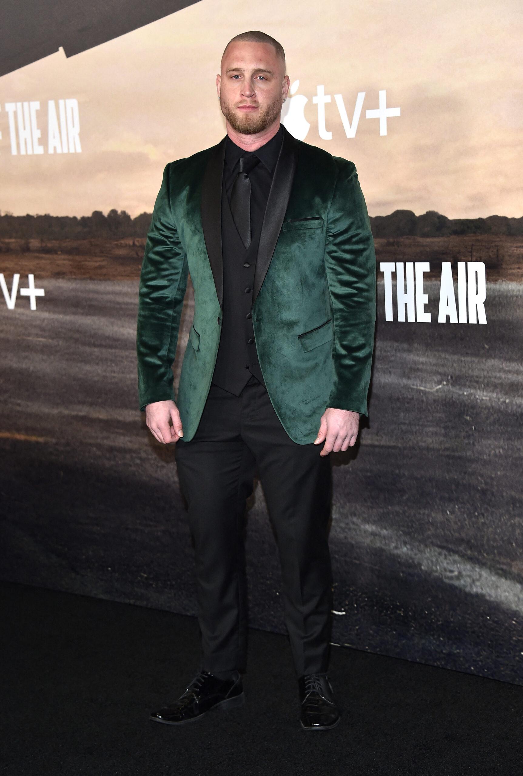 Chet Hanks posing on the red carpet in a green suit.