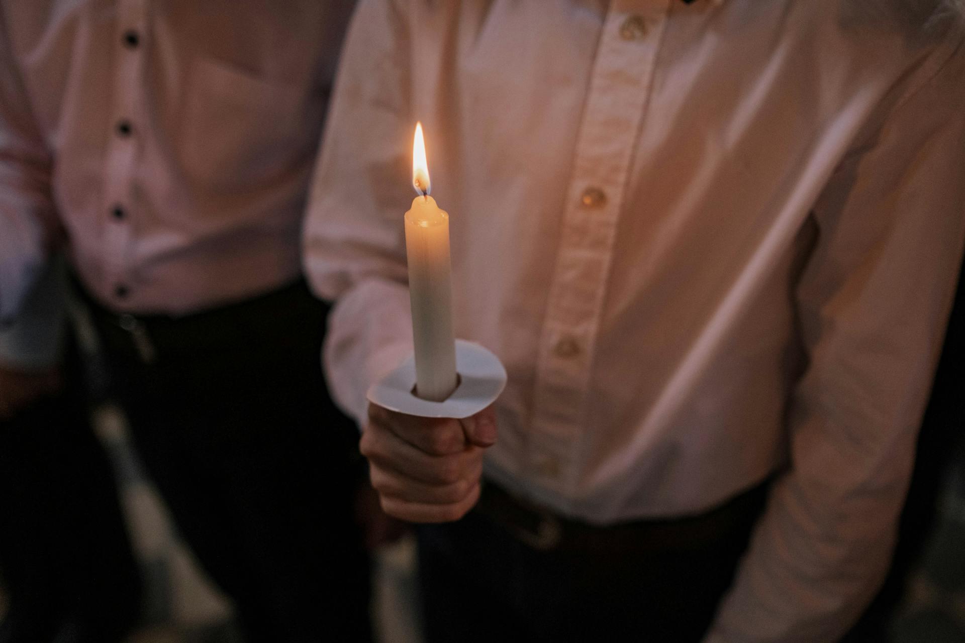 A man holding a candle for a vigil