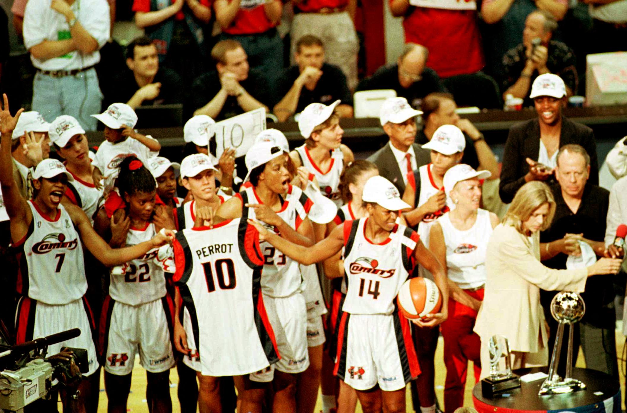 Houston Comets Cynthia Cooper and Tina Thompson hold the jersry of teammate Kim Perrot who died of cancer this year.