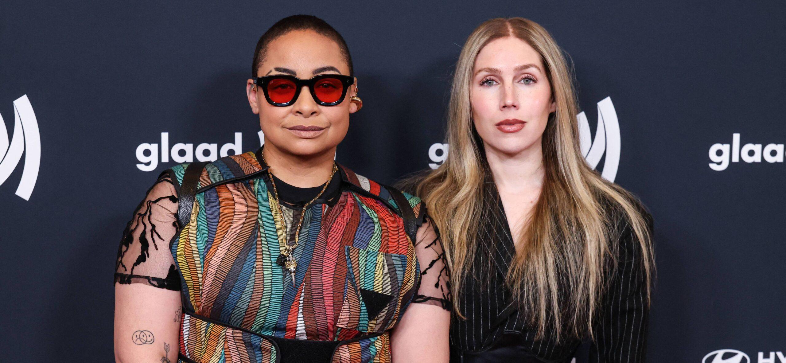Raven Symoné and her wife posing on red carpet.