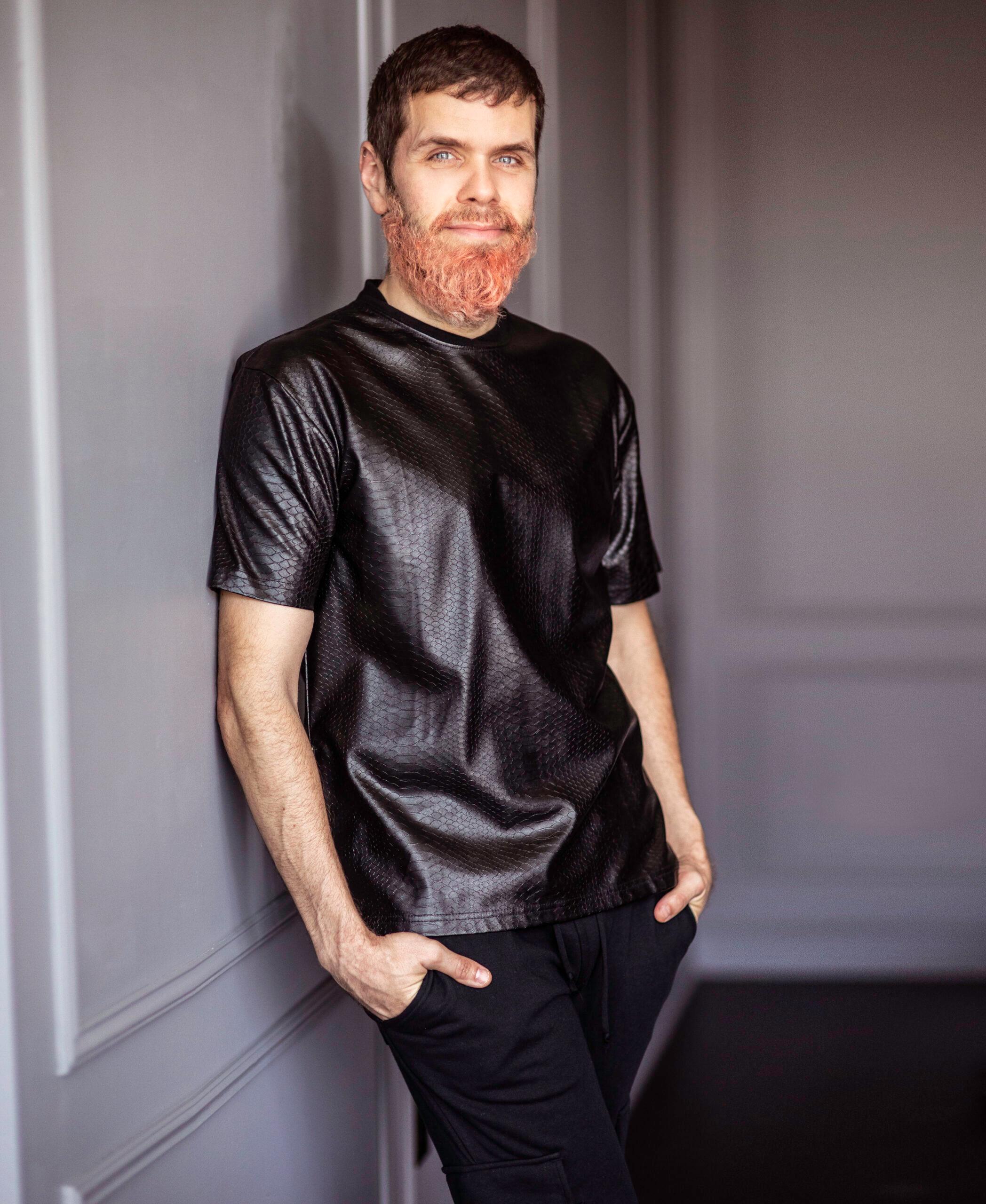 Perez Hilton leaning on wall