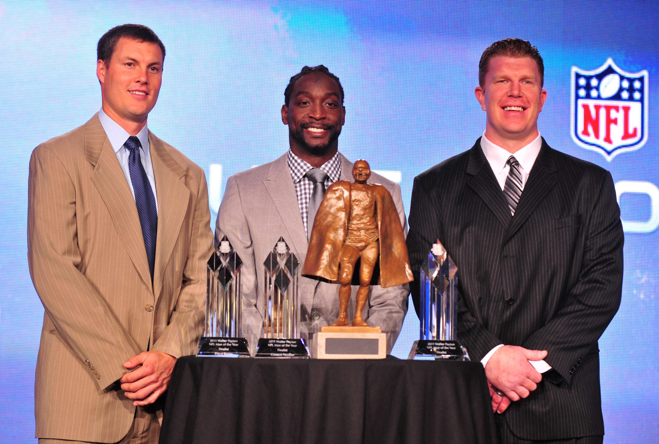 The 2011 Walter Payton NFL Man of the Year award finalist, Philip Rivers (L) of the San Diego Chargers, Charles Tillman (C) of the Chicago Bears and Matt Birk of the Baltimore Ravens pose with the award following a press conference during Super Bowl week in Indianapolis on February 3, 2012.
