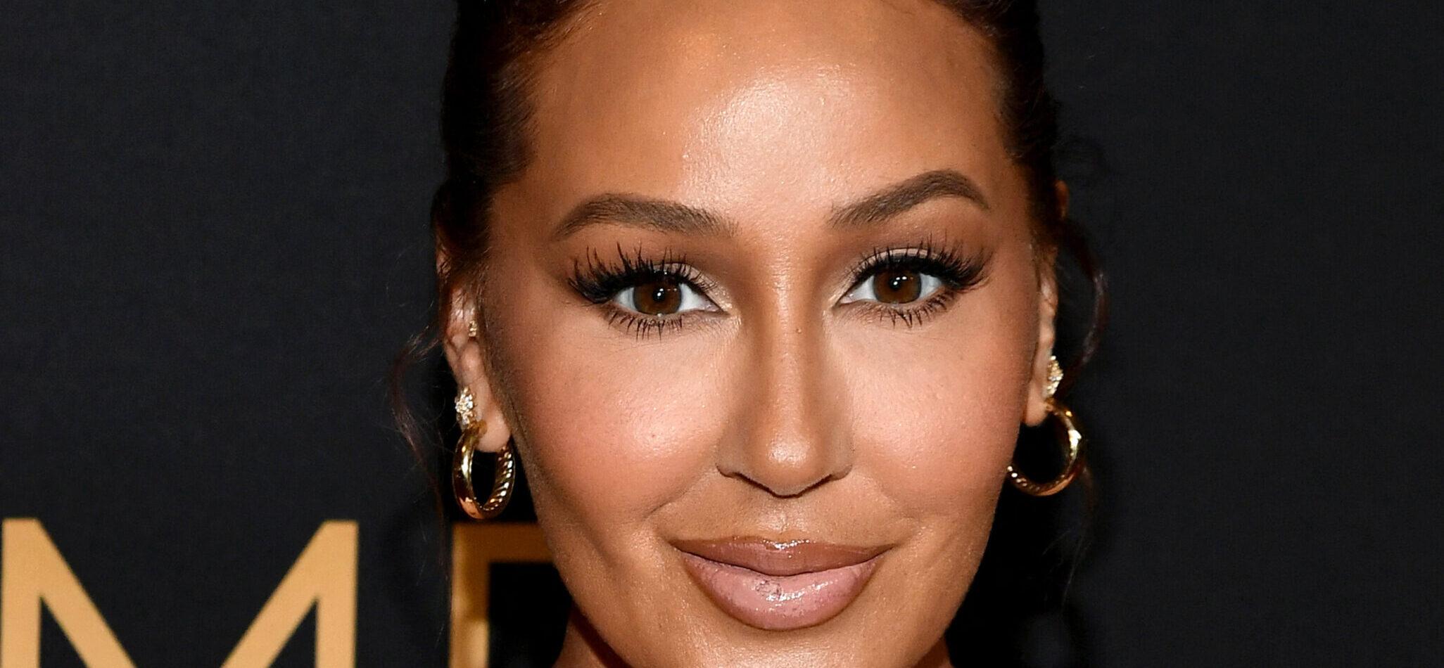 Adrienne Bailon posing for a picture on the red carpet.