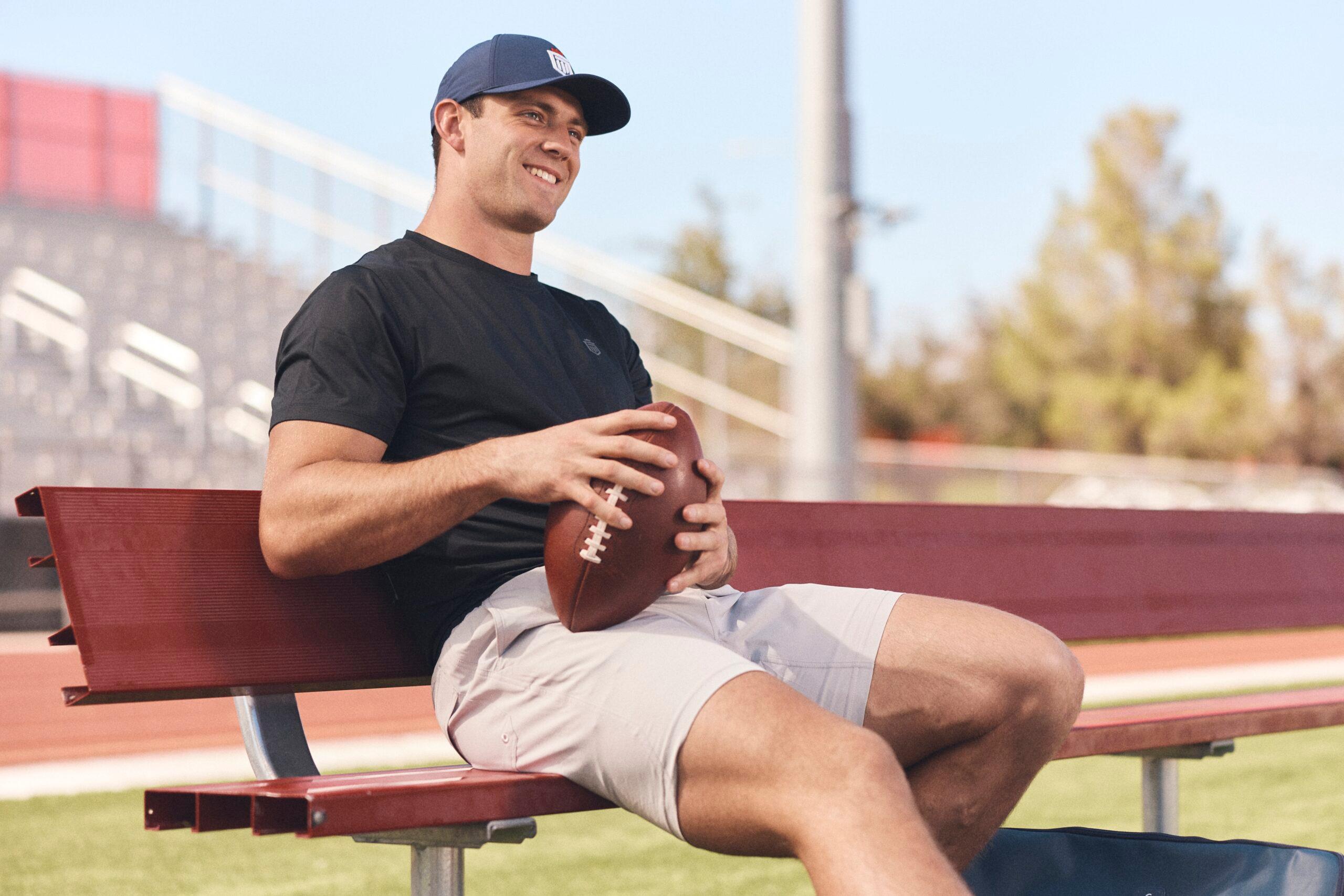 Brock Bowers holding football for Greatness Wins campaign