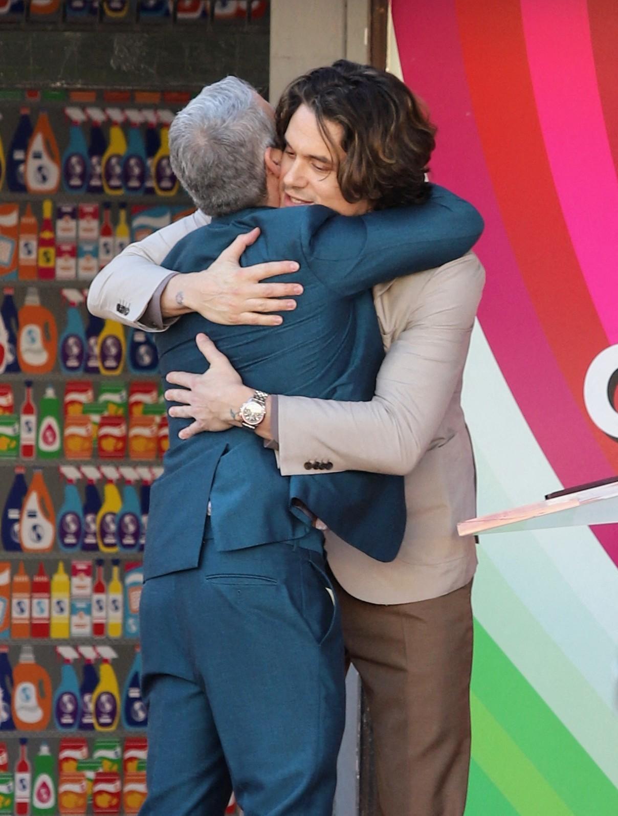 Andy Cohen hugging John Mayer.
