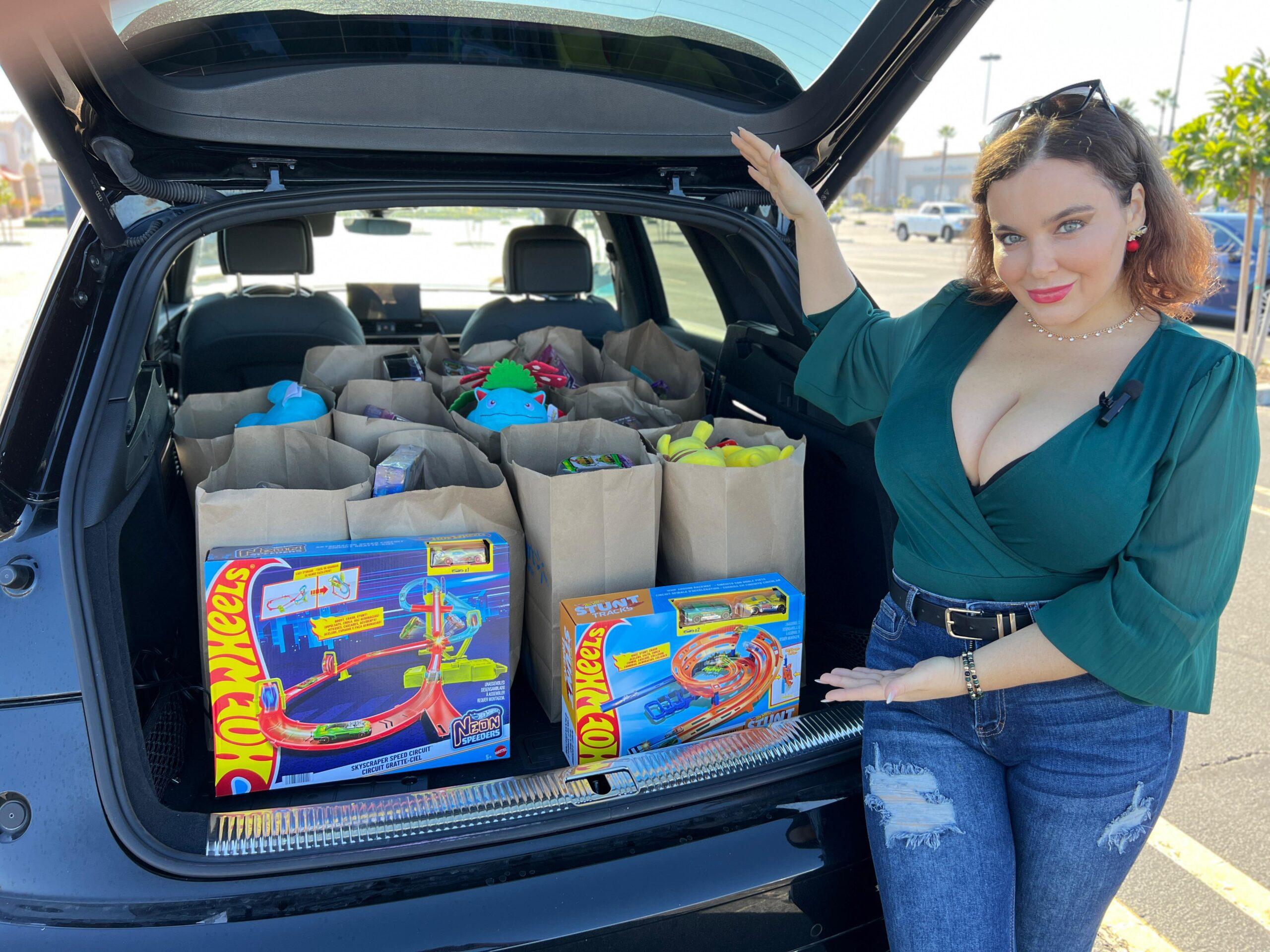Natasha showing off toys in the trunk of a car