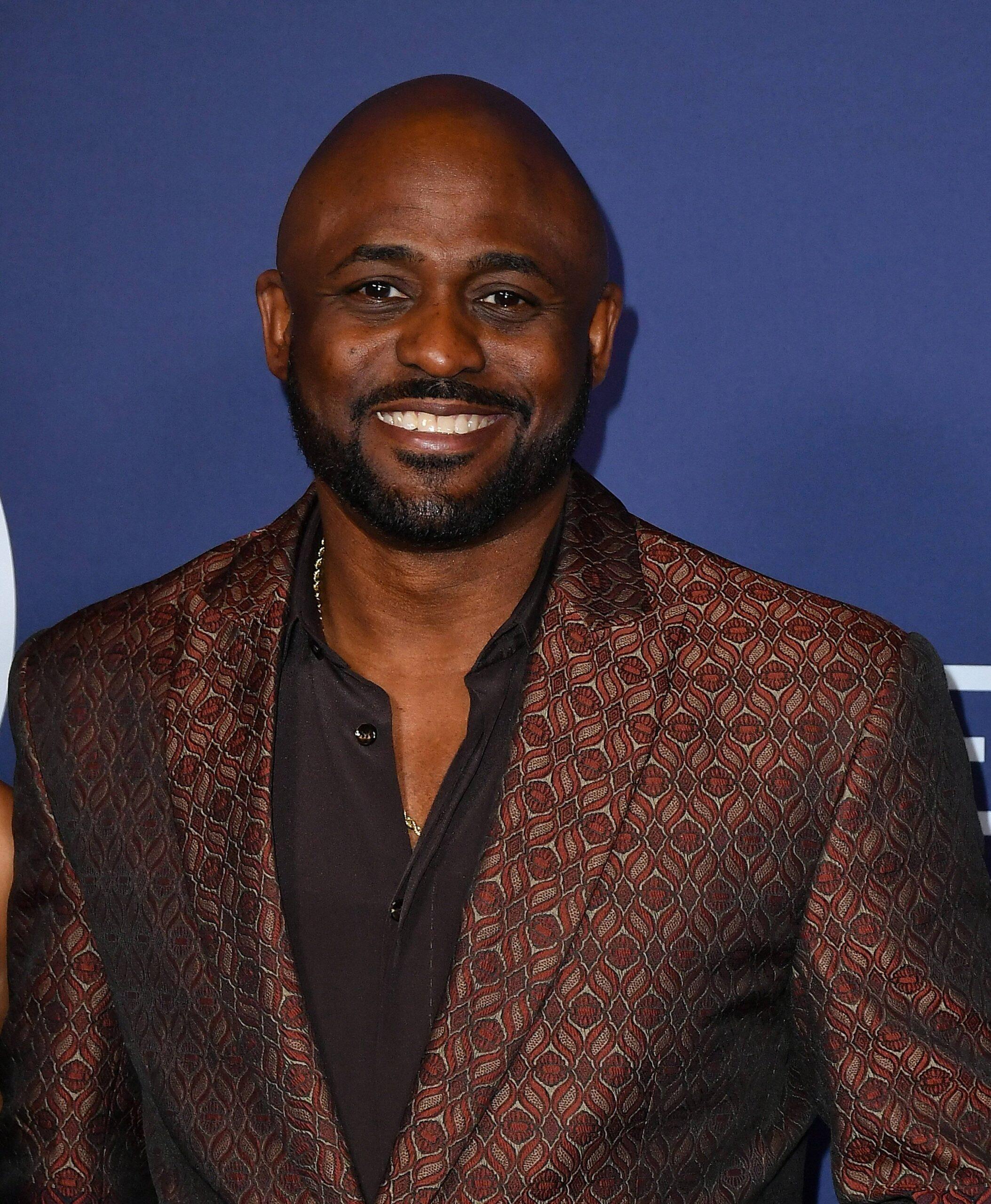 Wayne Brady posando no tapete vermelho. 