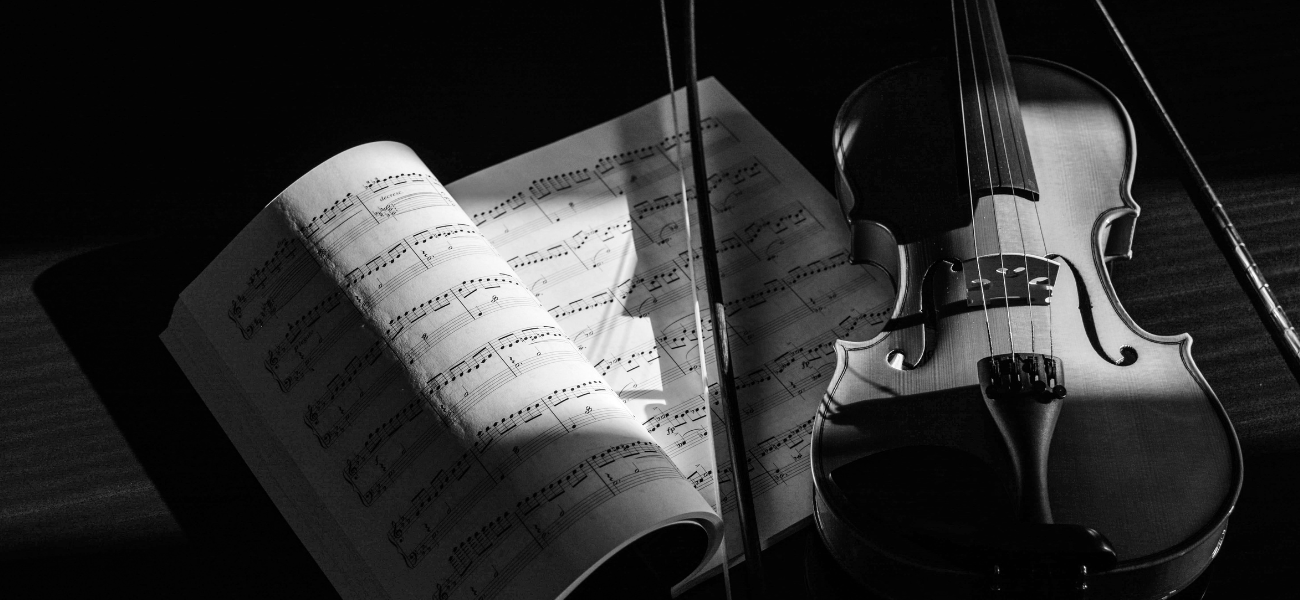 Black and white photo of violin and sheet music.
