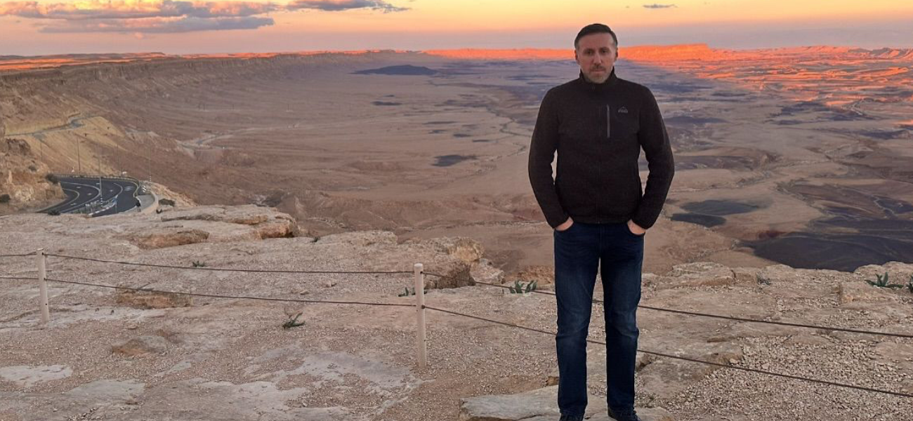 Man standing in desert at sunset