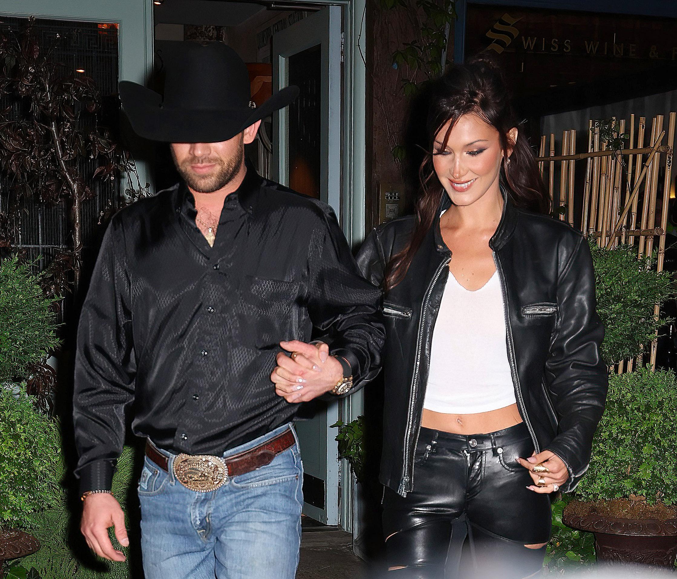 Bella Hadid holds hands with her boyfriend Adan Banuelos as they leave her Orabella party