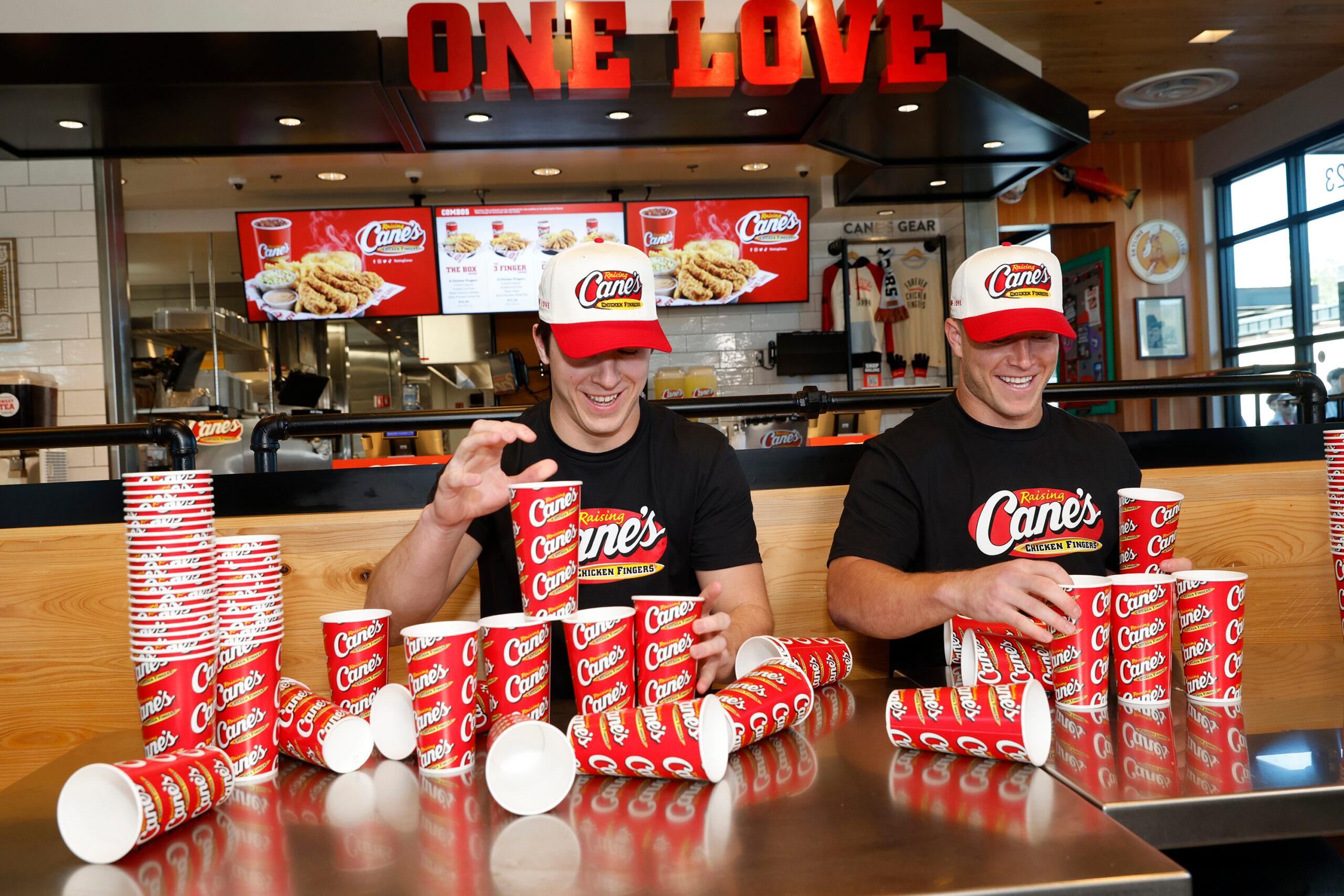 Christian and Luke McCaffrey Work Pre-Pro Bow Shift at Raising Cane's facing off in cup stacking During Super Bowl Week