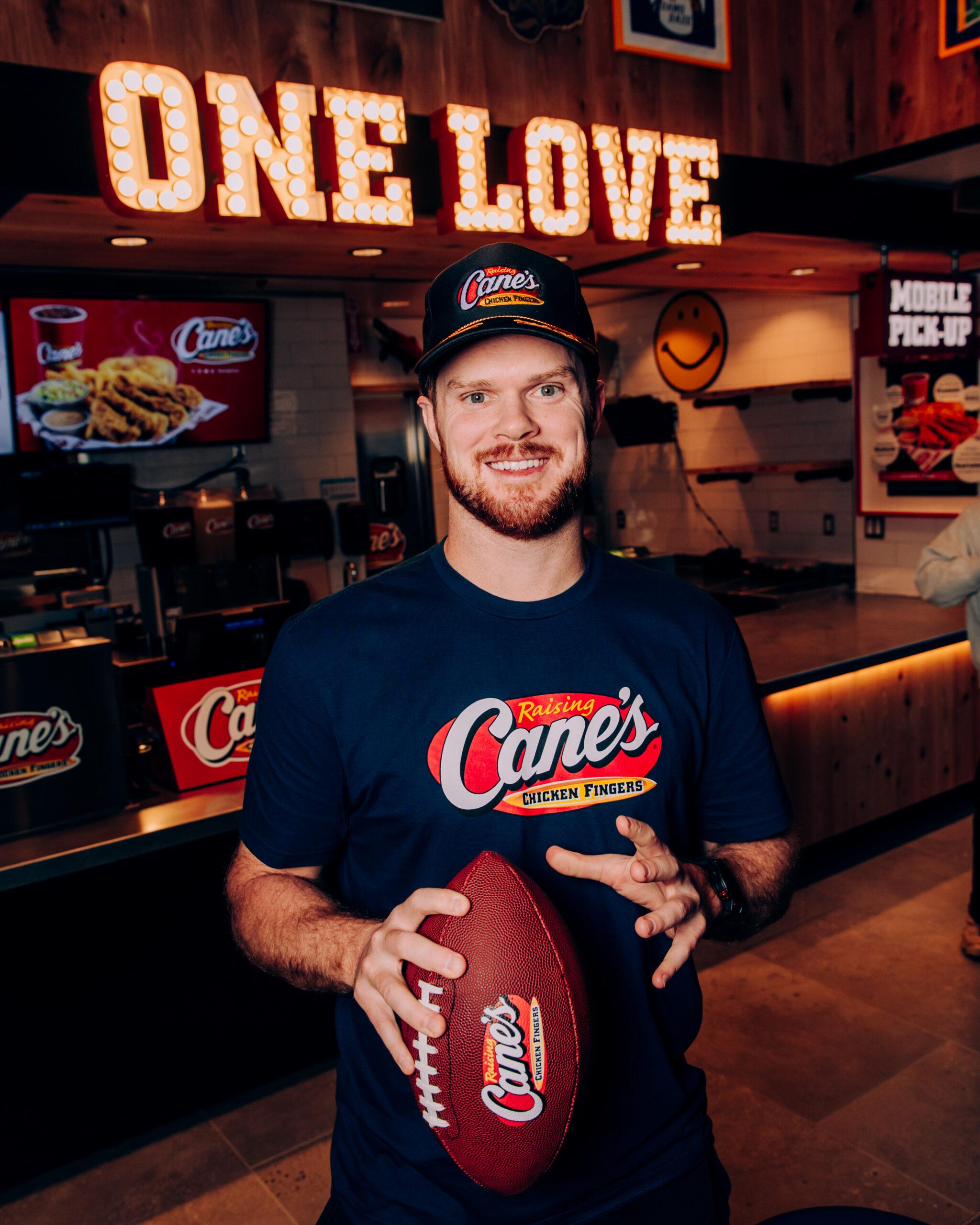 Sam Darnold holding football at Raising Cane's