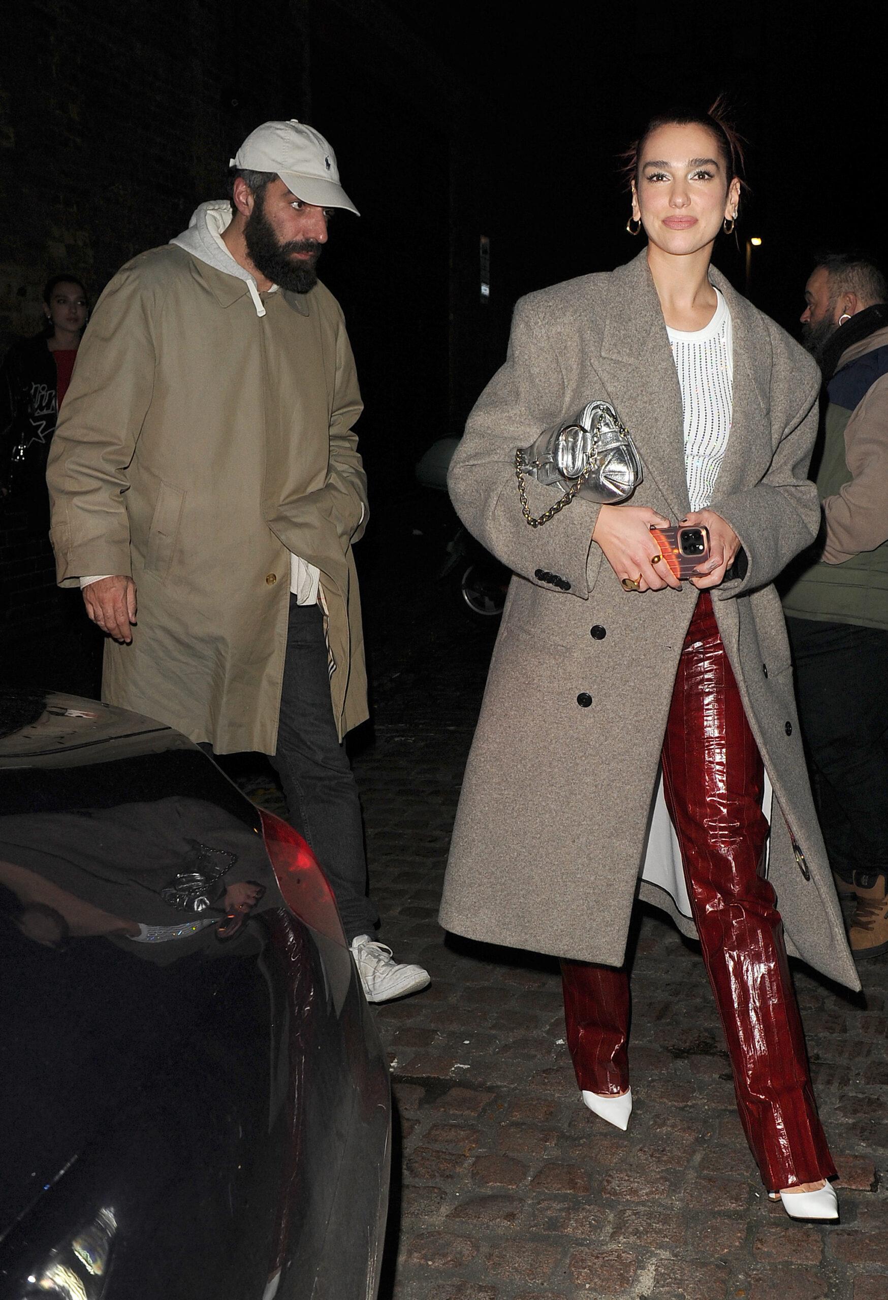 Dua Lipa enjoys a night out at the Chiltern Firehouse with her brother Gjin Lipa and her boyfriend Romain Gavras. Dua wore a grey trenchcoat and red snakeskin trousers