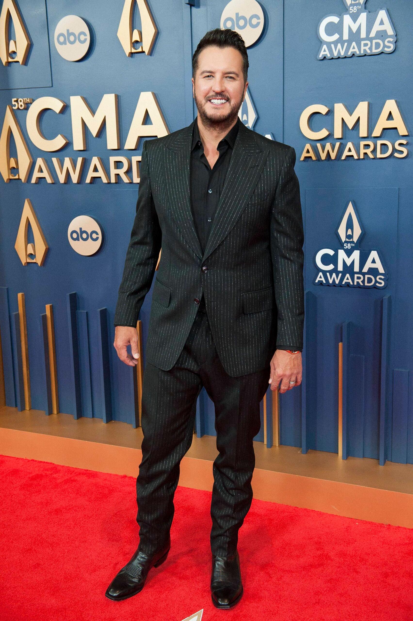 Luke Bryan standing on the CMA red carpet 