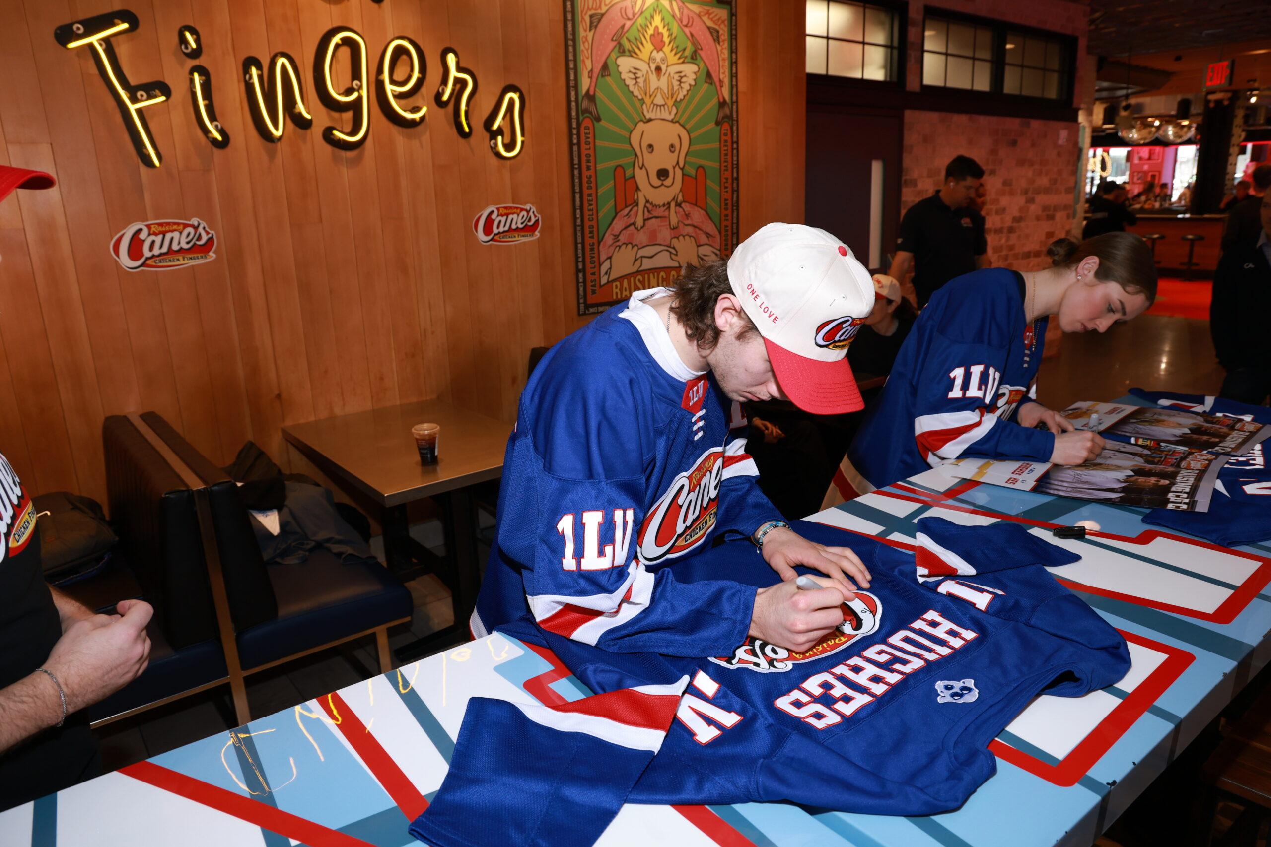 Hockey Stars Caroline Harvey And Jack Hughes Work A Celebratory "Shift" At Raising Cane's Times Square Global Flagship