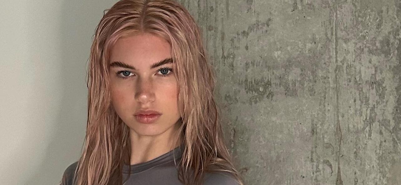 Brittan Byrd Steps Under A Waterfall In A Cut-Out Blue Swimsuit