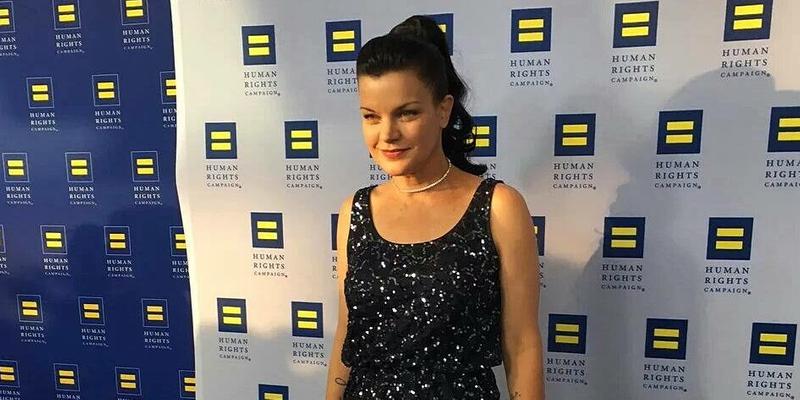 A photo showing Pauley Perrette in a black sleeveless dress