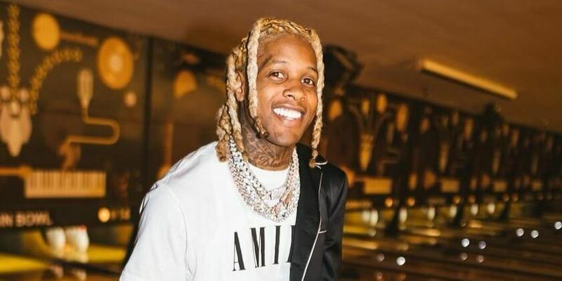A photo showing Lil Durk smiling at the camera at an event.