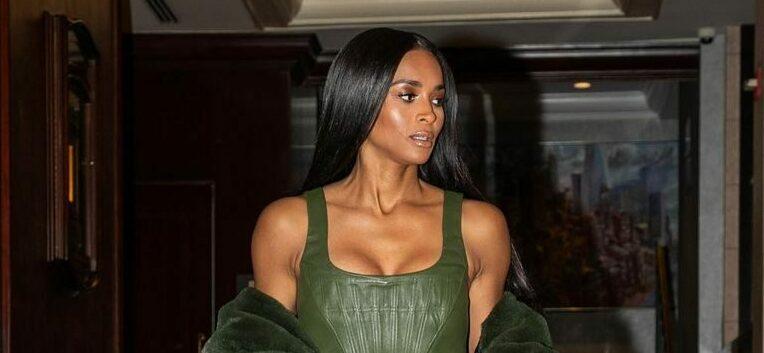 A photo showing Ciara coming down a flight of stairs in a green three-piece outfit