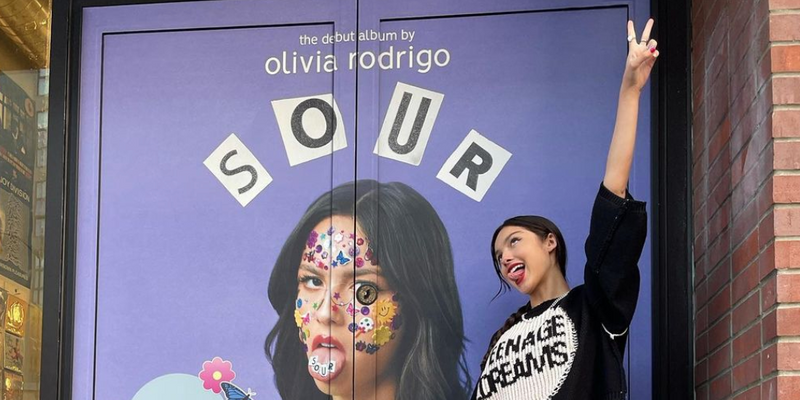 Olivia Rodrigo posing in front of 'Sour' door