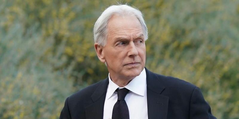 An amazing photo of Mark Harmon sporting a black suit with a white T-shirt and black tie.
