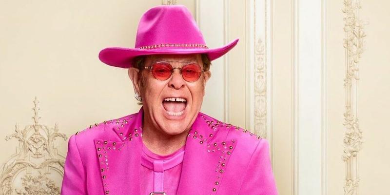 A photo showing Elton John in a pink suit and cowboy hat.