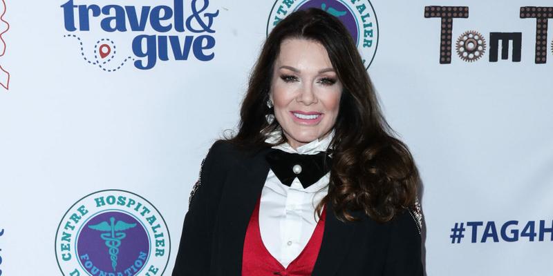 A photo showing Lisa Vanderpump sporting a black suit paired with a red and white inner-wear and black bow tie.