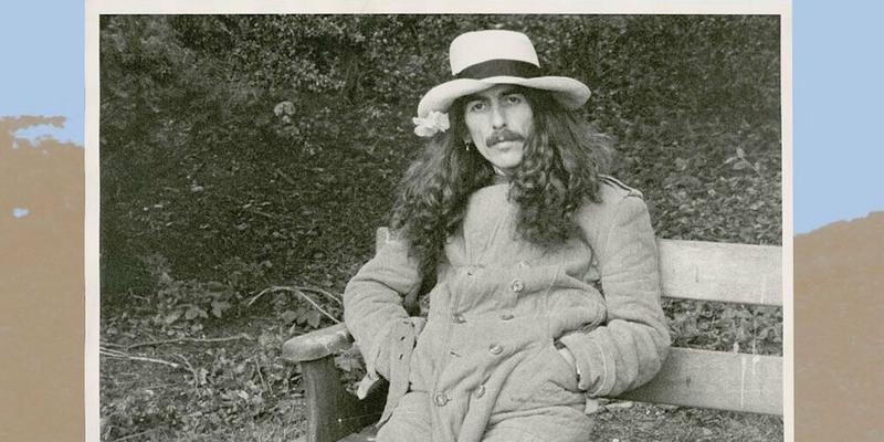 A throwback photo of George Harrison sitting on a bench.