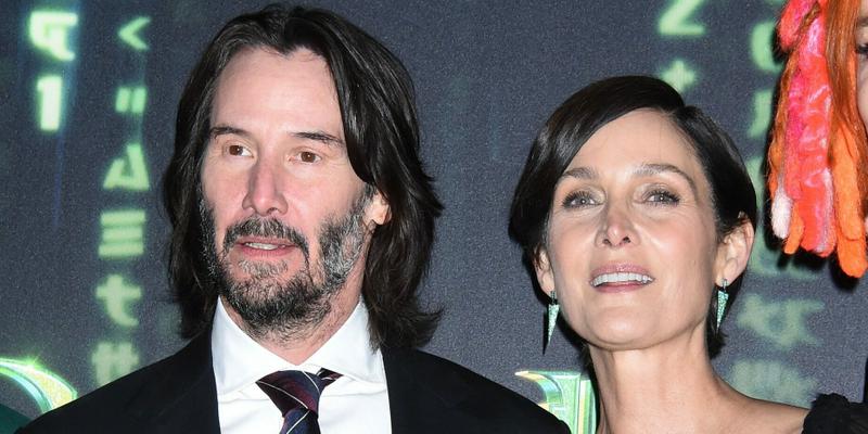 Keanu Reeves and Carrie-Anne Moss posing for the camera.