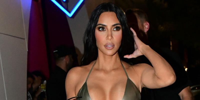 Kim Kardashian wears a silver latex bikini top with matching leggings as she and sister Khloe Kardashian arrive to her Skims pop-up event in Miami