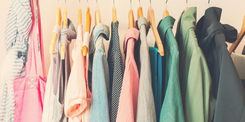 Women's summer clothes hanging in a closet.