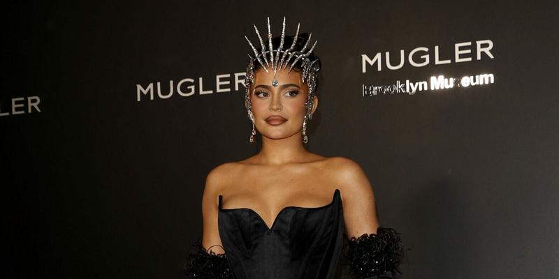Kylie Jenner can barely walk wearing a one of a kind skin tight apos Mugler apos dress to the exhibition opening in New York City
