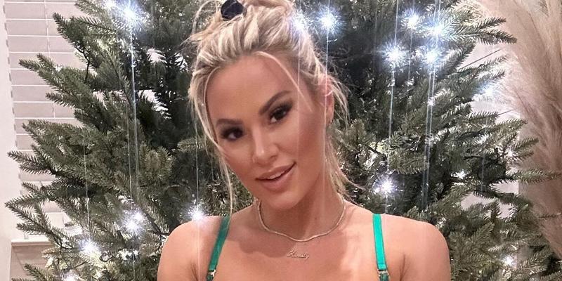 Kindly Myers poses in front of her Christmas tree in green lingerie