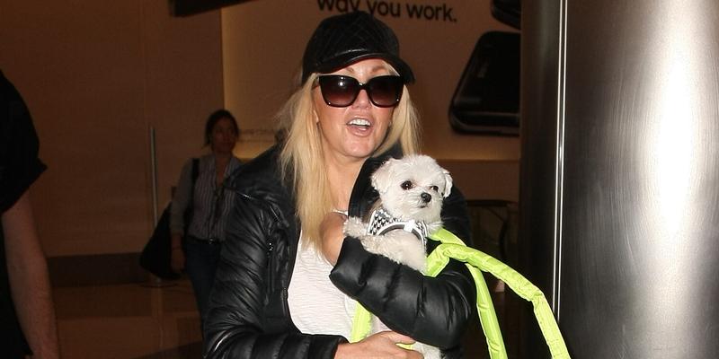 Heather Locklear looks casual and dressed down as she hold on tight to her dog as she jets out of LAX