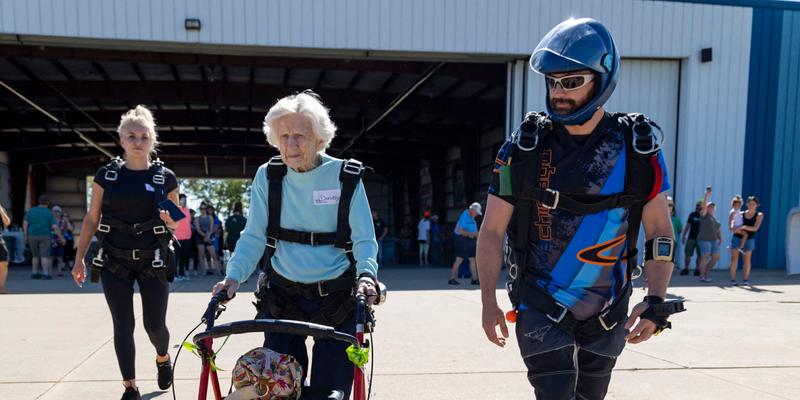 Skydiver Dorothy Hoffner, 104, pushes her walker out to the plane with tandem jumper Derek Baxter
