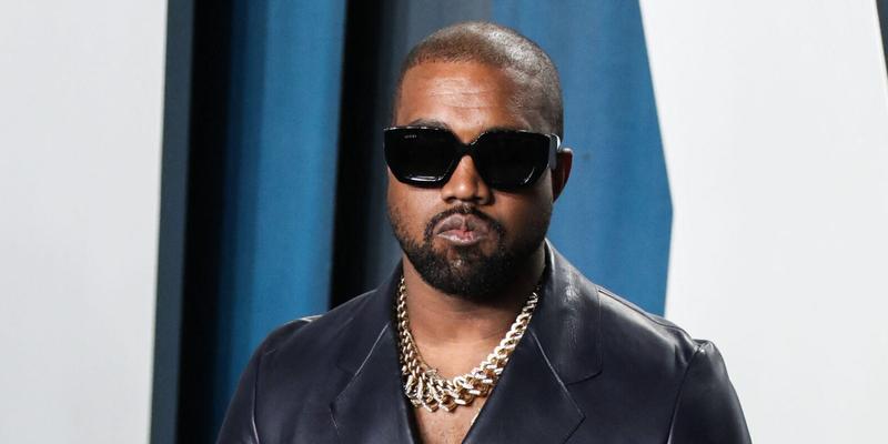 Kanye West wearing a black suit