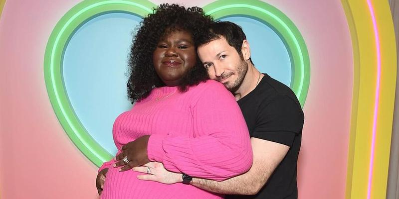Gabby Sidibe's husband Brandon Frankel embraces her from behind.