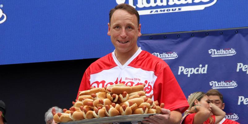 Joey Chestnut holding a plate of hot dogs