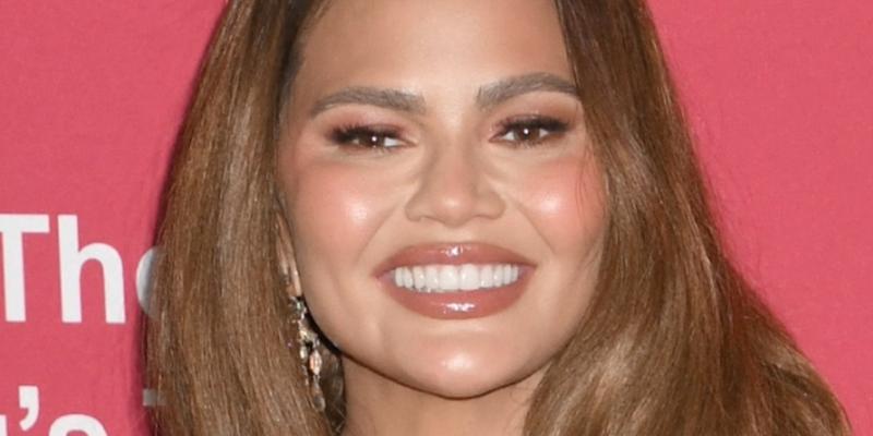 Chrissy Teigen smiles at an event