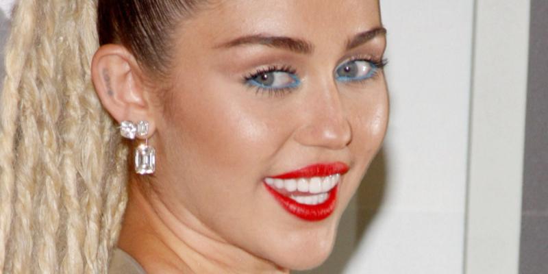 Miley Cyrus poses with red lipstick