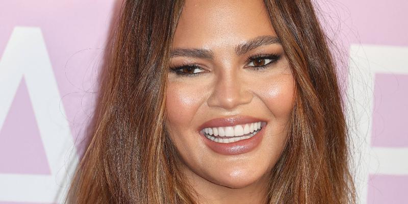 Chrissy Teigen smiles at an event