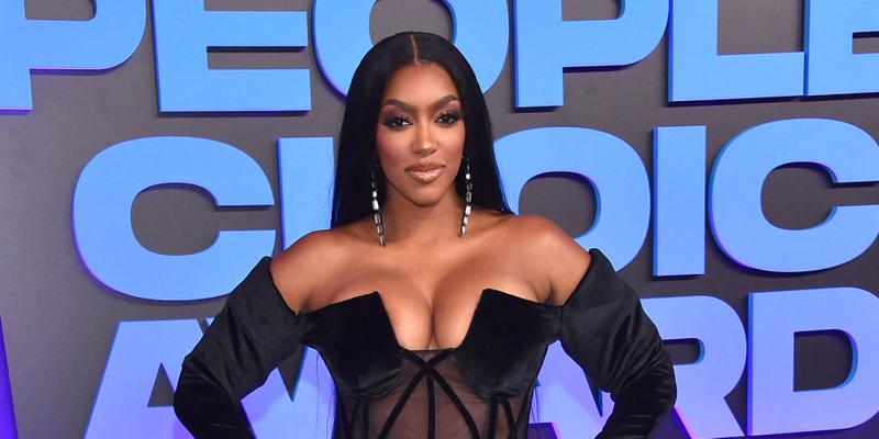 Porsha Williams posing in a black dress on the red carpet.