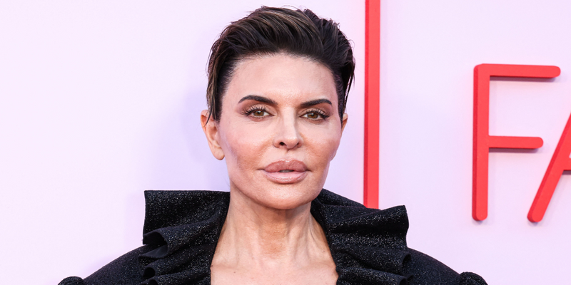 Lisa Rinna posing in a black outfit on the red carpet.