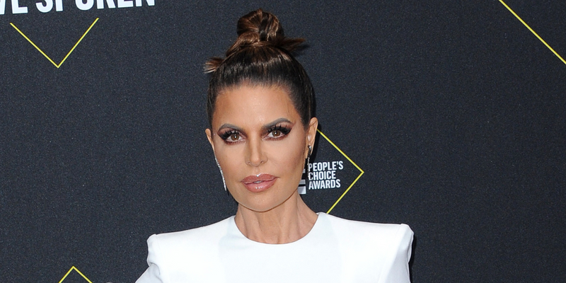 Lisa Rinna posing on the red carpet in a white dress.