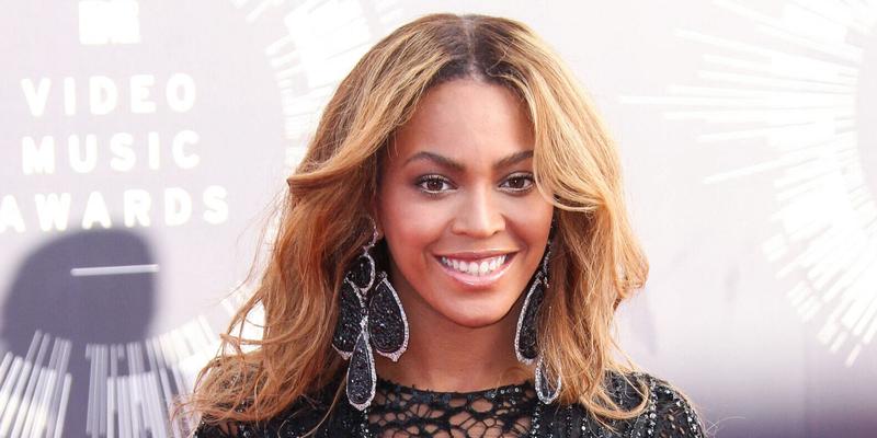 Beyoncé posing in a black dress on the red carpet.