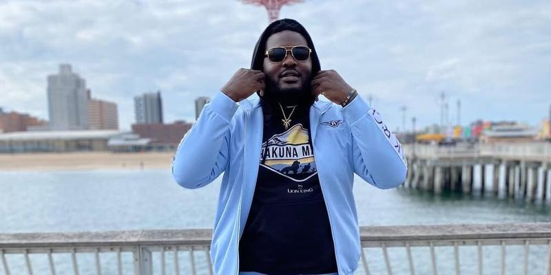 Ronald Ollie in a blue tracksuit in front of a beach.